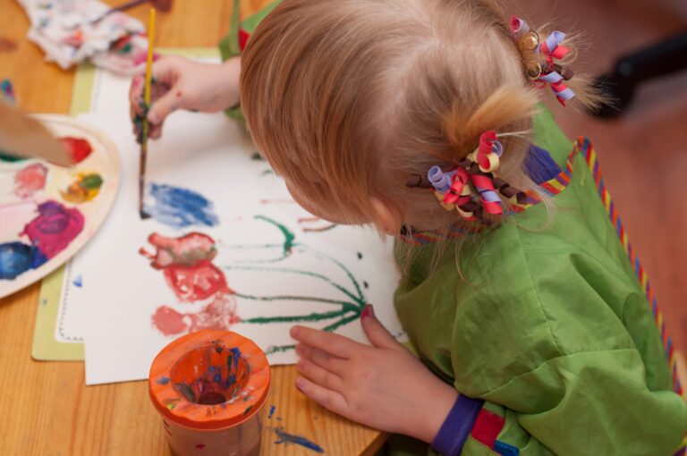 a little girl painting flowers with a paintbrush